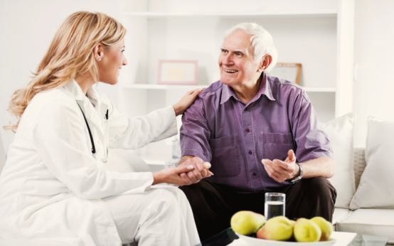 A Samaritan Services nurse sitting with a client in his home